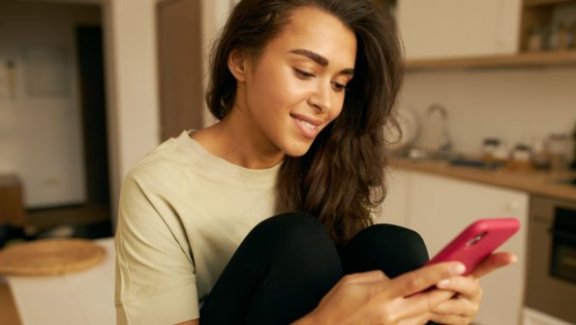 apps that eat up data, woman on phone in kitchen