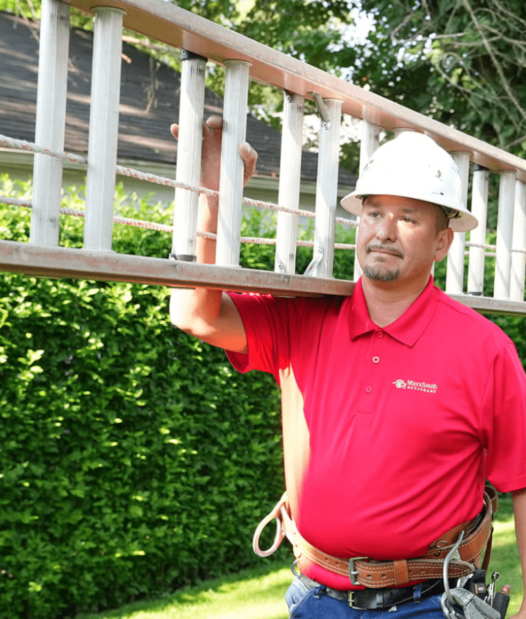 MaxxSouth employee carrying a ladder on his shoulder